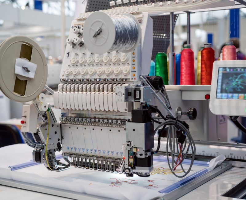 Automatic industrial sewing machine for stitch by digital pattern. Modern textile industry.