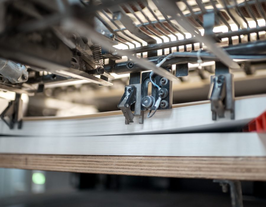 Fragment of the offset printing machine during the printing at the manufacturing